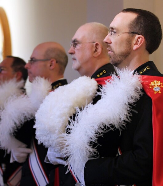 men in uniforms holding hats